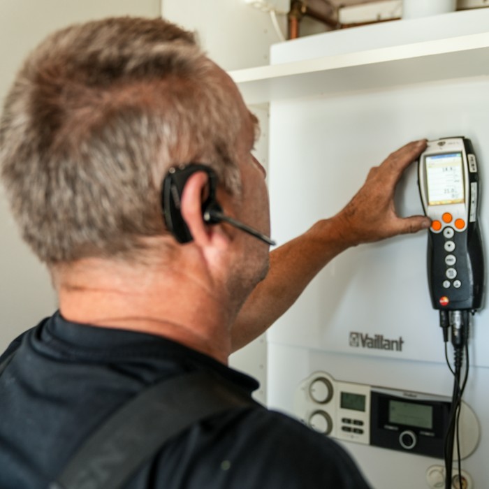 VVS-tekniker justerer indstillinger på Vaillant varmepumpe med måleinstrument